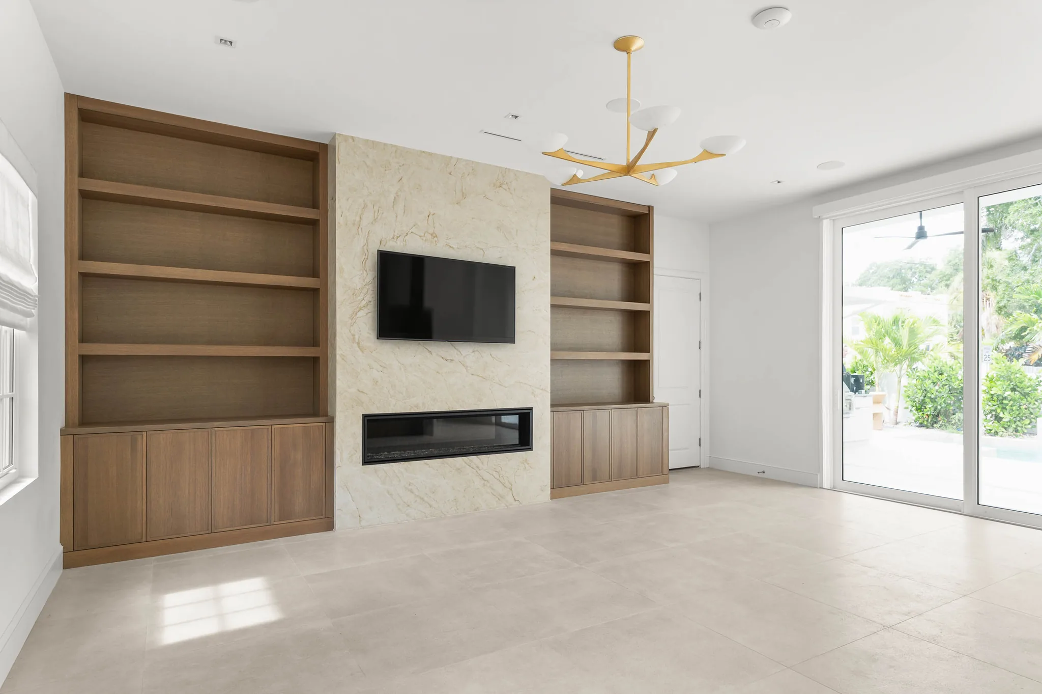 Great room with linear fireplace and white oak shelving beside the back garden door