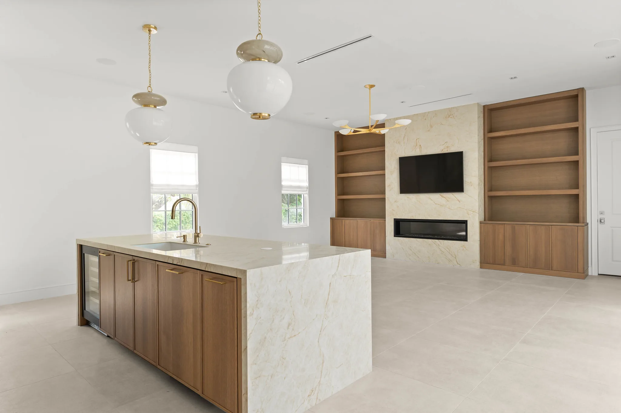 Kitchen island opening to the great room and fireplace wall