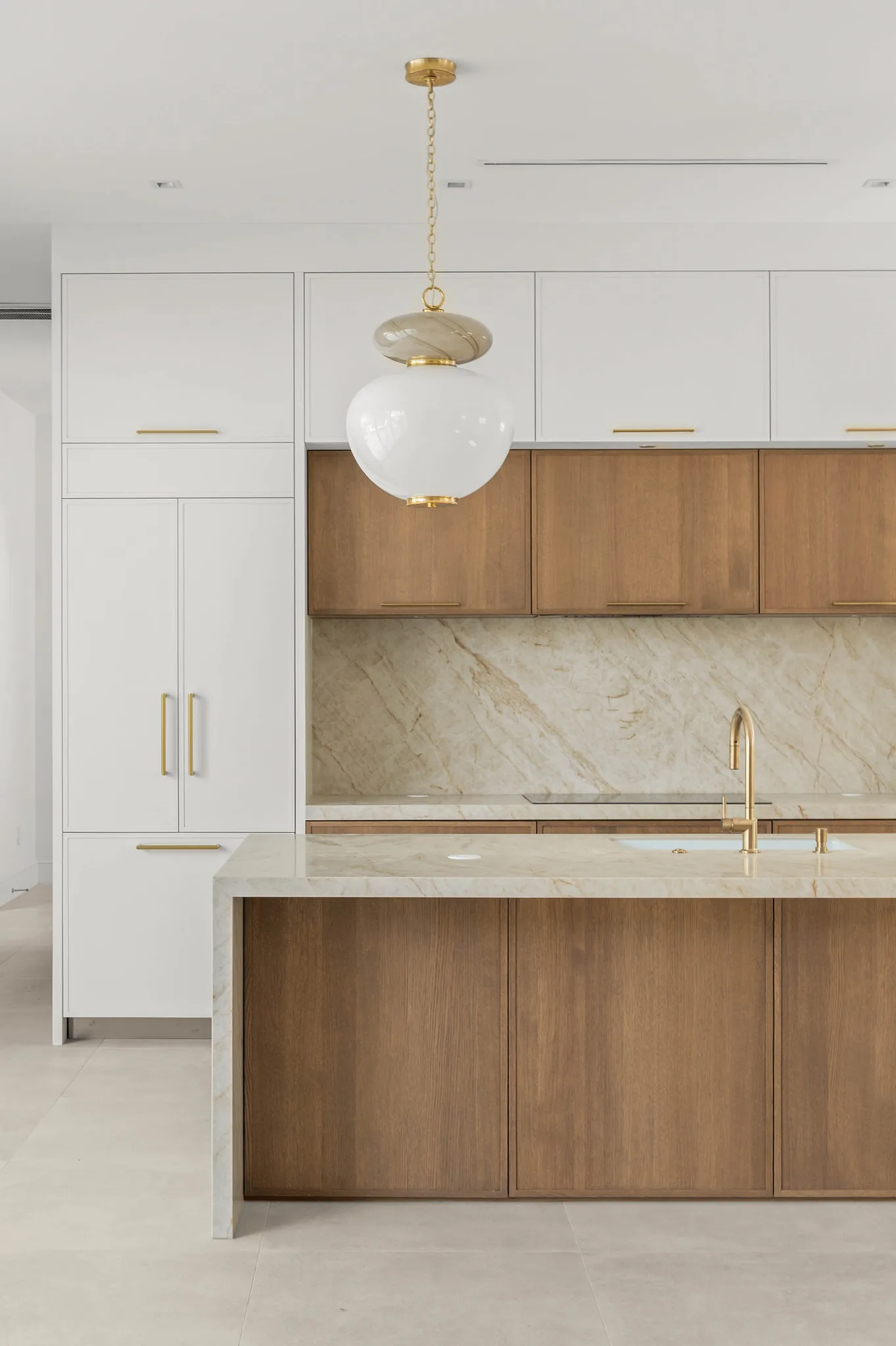 Two-tone kitchen cabinetry in white and white oak with brass hardware