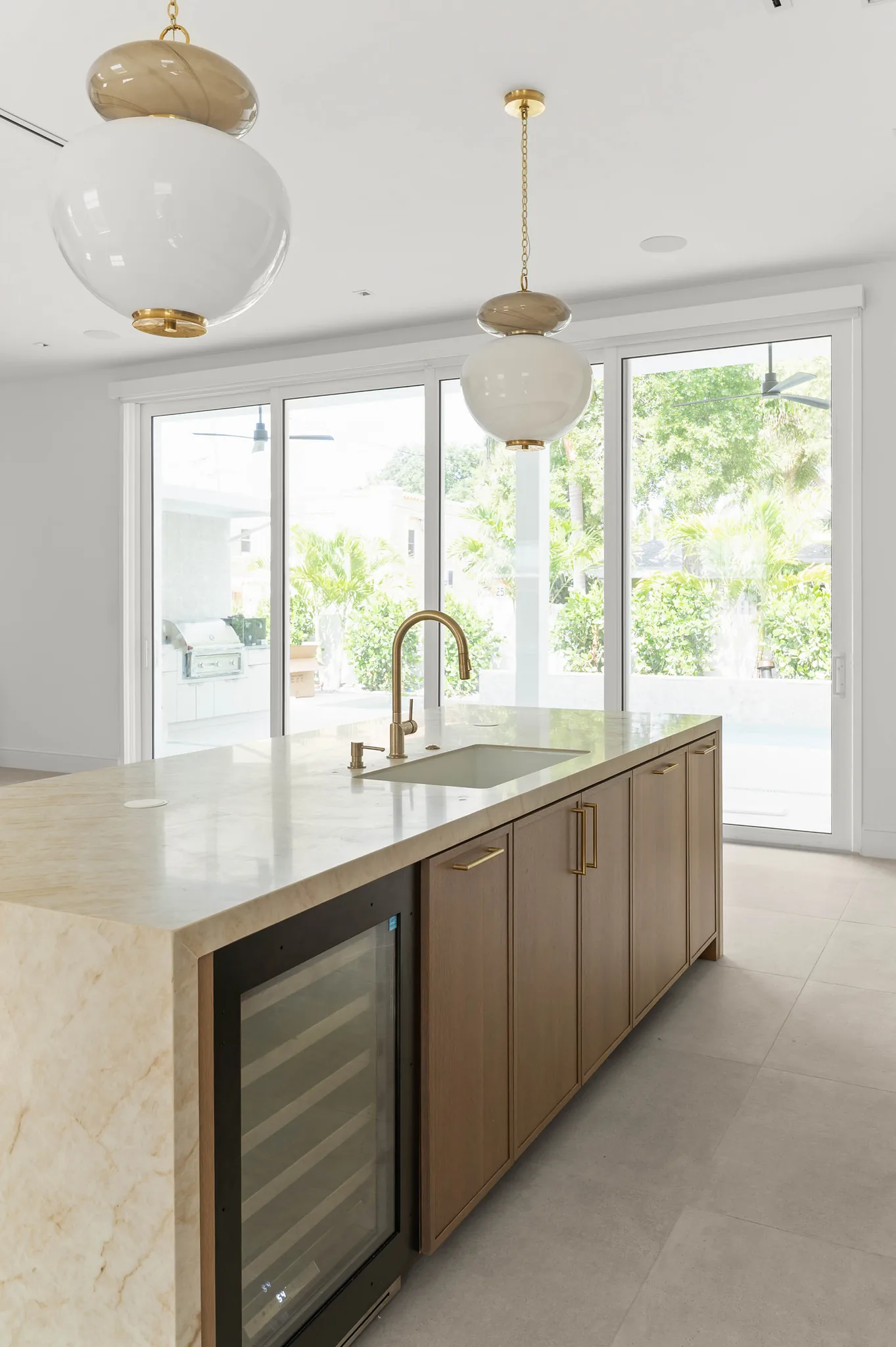 Kitchen island with brass faucet and wine chiller overlooking the lanai
