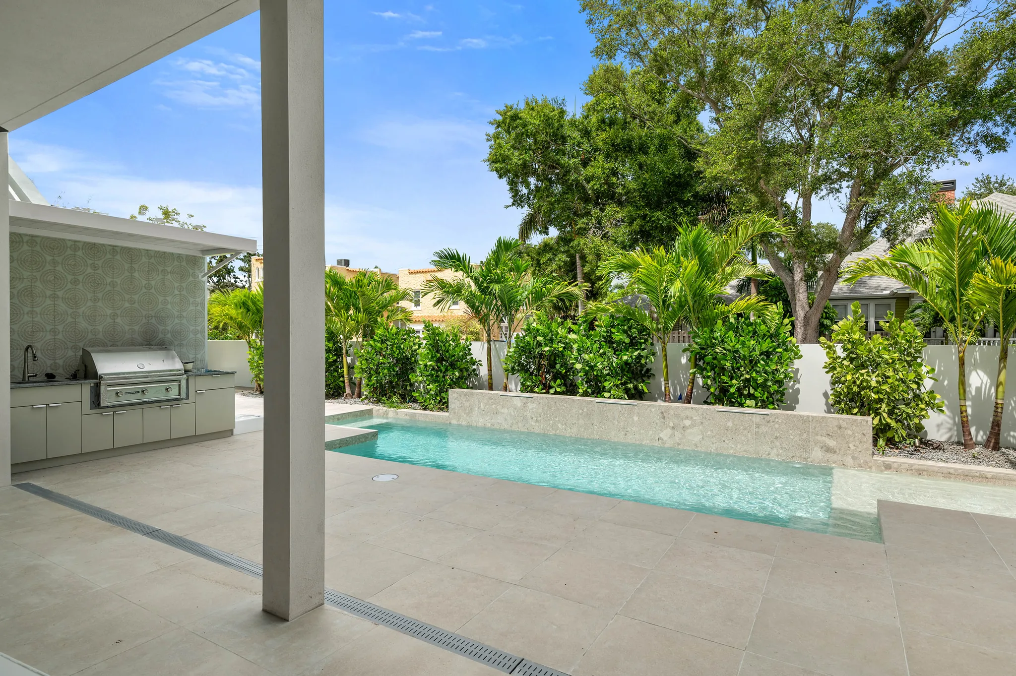 Covered lanai with outdoor kitchen beside the pool