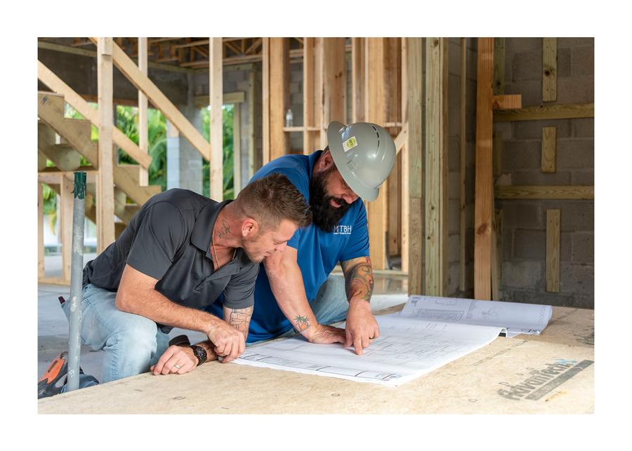 two workers over blueprint